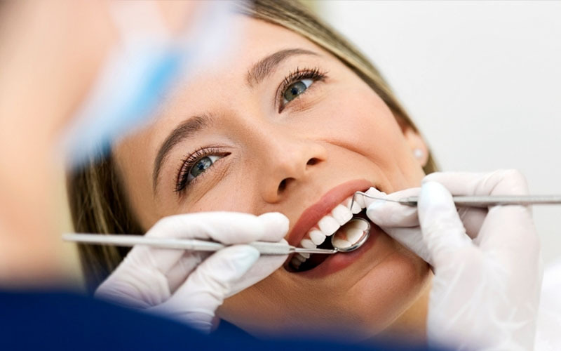 A dental examination using a small mirror to look at a patient's teeth.